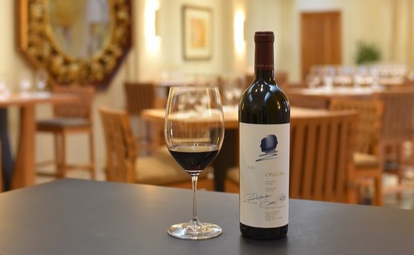 Glass of Opus One beside the bottle on the bar of the Salon with tables in the background